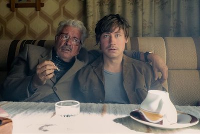 Lustvolles Arbeiten: Beim Dreh des Films "Stasikomödie" mit Regisseur Leander Haußmann wurde viel improvisiert. Henry Hübchen (links) als MfS-Führungsoffizier Siemens in einer Szene mit David Kross in der Rolle des Ludger Fuchs, der die Künstlerszene des Prenzlauer Bergs infiltrieren soll. 