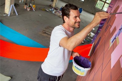Robert Deutsch aus Leipzig, zum dritten Mal bei der Ibug, malt mit Farbpigmenten aus der der ehemaligen Papierfärberei. Auch das Motiv seiner Arbeit für das Festival bezieht sich auf die Papierherstellung. Die Idee kam ihm beim Rundgang durch die größtenteils brachliegende Fabrik. 