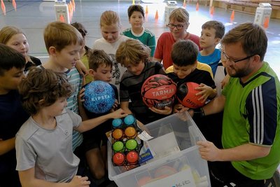 Markus Albitz (rechts) vom Verein Expika überreichte den Schülern eine Kiste mit Sportmaterial für Bewegung in den Pausen und im Unterricht.