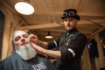 Ein Barbierstudio mit Friseur Martin „Doc Snyder“ Schneider aus Plauen (rechts) gehörte zur historischen Schlossweihnacht auf Schloss Voigtsberg in Oelsnitz. Einer seiner Kunden war Mario Branse aus Syrau.