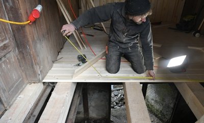 Zimmerermeister Arndt Baltzer aus Brand-Erbisdorf verlegt gerade die Dielung im Überbau über dem Wassergraben.