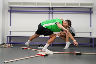 Neuzugang Ryan Malone bei einer der Beweglichkeitsübungen des Functional-Movement-Screening-Testverfahrens. Im Hintergrund Athletiktrainer Nils Brendel.