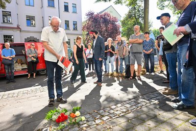 Albrecht Geißler legt Blumen an den neuen Stolpersteinen nieder.