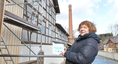Die Brettmühle in Mulda wird weiter saniert - auch mit Fördermitteln des Bundesministeriums für Ernährung und Landwirtschaft in Zusammenarbeit der Beauftragten der Bundesregierung für Kultur und Medien. Petra Schumann vom Mühlen-Förderverein zeigt das Schild "Landwirtschaftliche Museen 2023".