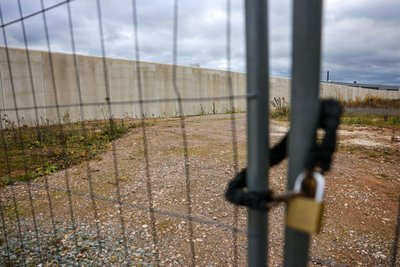 Ein Vorhängeschloss hängt an einem Bauzaun auf der Baustelle der gemeinsamen Justizvollzugsanstalt von Sachsen und Thüringen.