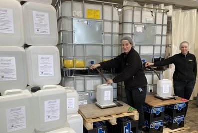 Die Produktionsmitarbeiterinnen Doreen Schmidt (l.) und Anja Link von der Lautergold Paul Schubert GmbH in Lauter füllen den hochprozentigen Alkohol in Plastekanister ab. Statt Spirituosen stellt das Unternehmen nun ein eigenes Handdesinfektionsmittel her.  