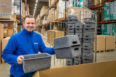 Versandleiter Stefan Lohs verpackt im Hochregallager Vliesboxen für die Möbelindustrie.