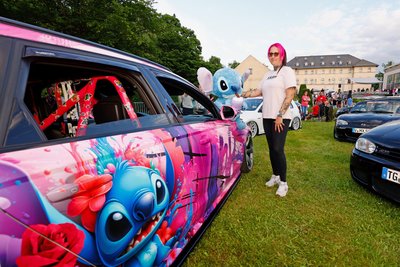 Romy Lochmann mit pinkem Haar, buntem Auto und ihrem Liebling "Stitch".