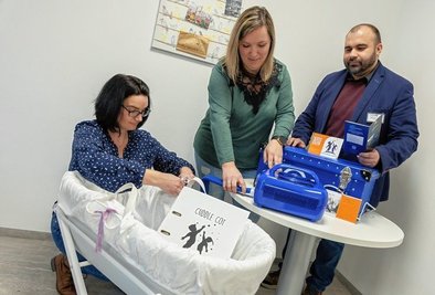 Die Hebammen Antje Kovacs (links) und Tina Winkler übergeben die Wiege an Hospiz-Leiter Christian Wilke. 