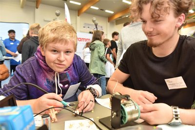 Jonas Jackisch mit Lötgerät, er stellt einen Minirobotor bei Sebastian Günther am Stand von Albis-Elcon GmbH Hartmannsdorf her. Foto: Christof Heyden