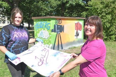 Schulleiterin Katrin Fleischer mit Mia aus der 6a. Graffitikünstler Cebu signierte Mia ein T-Shirt.