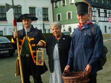 Der Zwotaer Nachtwächter Georg Carsten Eibisch (links) 2011 mit Ute Schulz und Lothar Steinebach aus Solingen, die in der historischen Tracht eines Messerschleifers und einer Lieferin mehrfach an den Vogtländischen Mundart-tagen teilnehmen. 