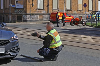 Ein Polizist nimmt ein beteiligtes Auto unter die Lupe.