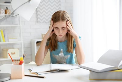 Viele Schüler fühlen sich durch Hausaufgaben und Arbeiten, Prüfungen und Notendruck zunehmend gestresst.