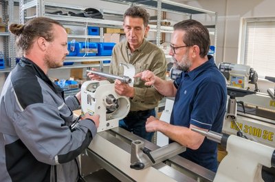 Robin Leonhardt bespricht mit Roland und Martin Steinert (v. l.) bei der Montage einer Drechselbank ein technisches Detail. 