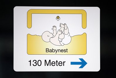 Ein Schild weist den Weg zum Babynest eines Krankenhauses.