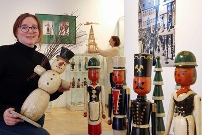 Jette Luckhardt mit historischen Pyramidenfiguren in der Weihnachtsausstellung.