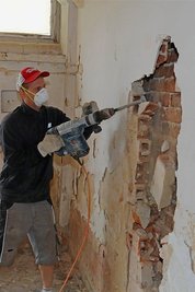 Marcel Hohnstein geht mit dem Stemmhammer gegen das überflüssige Ziegelwerk vor.
