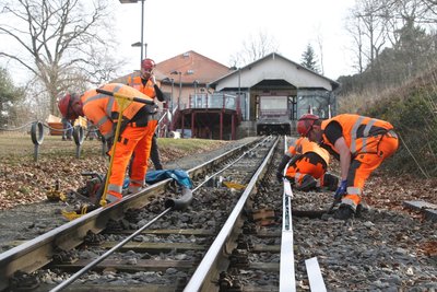 Eine alte Holzschwelle wird aus dem Gleisbett an der Drahtseilbahn entfernt.
