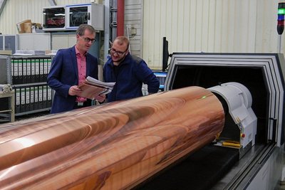 Mitarbeiter Frank Dögel (r.) und der Geschäftsführer der Sächsischen Walzengravur GmbH, Michael Wiegner, an einer Gravurmaschine, auf der Druckformen für Möbelfolie und Laminat gefertigt werden. 