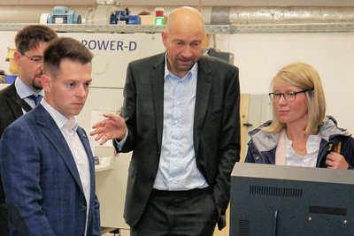 Abgeordneter Philipp Hartewig, Geschäftsführer Justus Rau und IHK-Chefin Cindy Krause (vorn v. r.) an einer Digitaldruckmaschine der Firma Innotex.