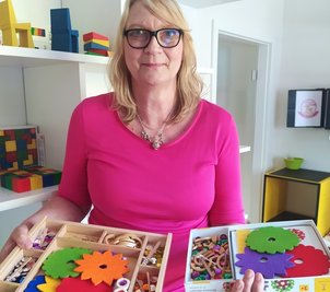 Barbara Seidler zeigt das neue Schmuckstein-Mandala. Die große Ausführung ist für Kindergärten, die kleine für zuhause. 