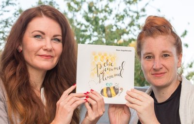 Katja Fugmann (l.) und Nora Engelbrecht mit dem Kinderbuch "Die Bummelhummel". 