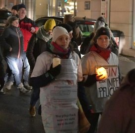 Einige protestierten mit Kerzen und Aufschrift gegen eine Impfpflicht.