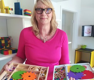 Barbara Seidler zeigt das neue Schmuckstein-Mandala. Die große Ausführung ist für Kindergärten, die kleine für zuhause. 