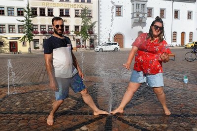 Auch Erwachsene wie Sophia und Yehia (Foto) nutzen die in den Obermarkt  eingelassenen Wasserspiele für eine willkommene Erfrischung. 