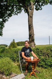 Der Voigtsdorfer Conny Albert bei einem Picknick in seinem Garten. Im Hintergrund der Baum, der am Montag gefällt werden sollte, um einen Transport für Windkraftanlagen zu ermöglichen. 