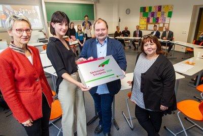 Katrin Beyer (l.) und Heike Schulze (r.) vom Landesamt für Schule und Bildung gratulieren Zwölftklässlerin Luisa Baumgärtner und Lessing-Direktor Frank-Maik Richter zum Sächsischen Schulpreis. 