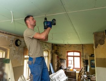 Im Inneren des Gebäudes gibt es immer wieder etwas zu tun. Rico Bernhardt befestigt an der Decke Trockenbauplatten. 