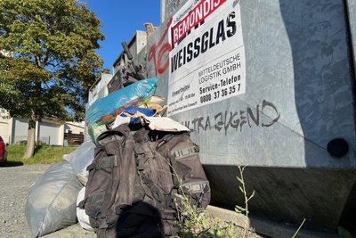 Am Roten Markt in Markneukirchen liegen Altkleider an den Glas- und Kleidercontainern.
