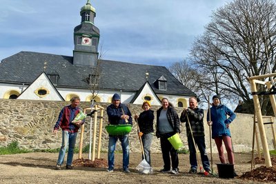 In Helbigsdorf wurde die Grünfläche vor der Kirche hübsch gemacht. Roland Neubert (2. v. l.) säte Gras aus.