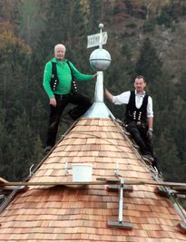 Dachdeckermeister Ulf Voit aus Netzschkau (links) hat zusammen mit seinem Mitarbeiter Jörg Schwabe die Turmhaube als Dachabschluss auf den Hungerturm gesetzt.