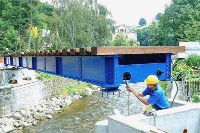 Das August-Hochwasser 2002 hatte tragende Teile der früheren Eisenbahnbrücke so beschädigt, dass sie gesperrt werden musste. Ein ersatzloser Abriss wurde verworfen. So kam es zum Neubau. Kosten: gut 170.000 Euro. Am 28. Juli 2004 ließ ein Autodrehkran die 15 Tonnen schwere Stahlkonstruktion einschweben. Die optisch dem Vorgängerbau nachempfundene Brücke wurde am 12. August 2004 eingeweiht. 