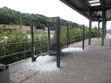 Offenbar mit Betonpflastersteinen und Schottersteinen haben Unbekannte Scheiben an der Haltestelle zerstört.