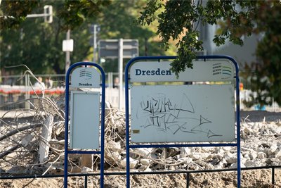 Eine leere Informationstafel der Sächsischen Dampfschifffahrt mit der Aufschrift „Dresden“ steht vor Teilen der eingestürzten Carolabrücke auf der Altstädter Elbseite.