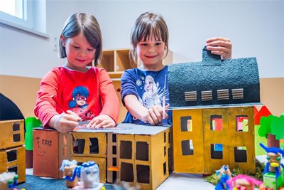 Luise Follmer (l.) und Ella Faßl mit dem Marktensemble: Rathaus plus Grundschule. Und: 14 Autos haben die Kinder gebastelt.