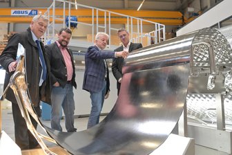 7-Millionen-Euro-Investition im Erzgebirge: Wäschemangel-Hersteller weiht neue Halle ein - Andy Groß, Geschäftsführer von Kannegiesser Aue (rechts), erklärte Gästen zur Einweihung der neuen Halle Details zur Produktion von Mangeln.