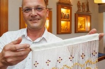 70 Jahre Turmmuseum: Forschung bringt Neues ans Licht - Was einst in vielen Stuben in Heimarbeit gefertigt worden ist, ziert nun auch Fenster im Turmmuseum Geyer. Leiter Lutz Röckert hat Perlfransengardinen bei Vorführungen angefertigt, passend zum Jubiläum. Foto: Ronny Küttner