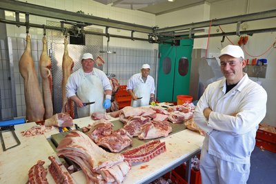 Von links: Danilo Köhler und Jürgen Böhme zerlegen die Tiere für die Weiterverarbeitung. Fleischermeister André Heinig ist Produktionsleiter und Produktentwickler bei „Heimatproviant“.