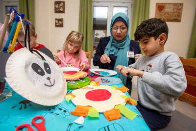 Erzieherin und Praktikantin Sayan Al Halebi hat mit Charlotte (7) und Zayn (5) Lampions für den großen Umzug am Freitag am Plauener Mehrgenerationenhaus gebastelt.