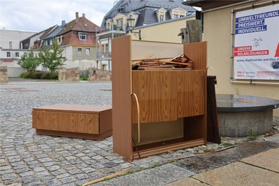Teile einer ausrangierten Schrankwand liegen an der Pumpe am öffentlichen WC am Werdauer Kirchplatz.