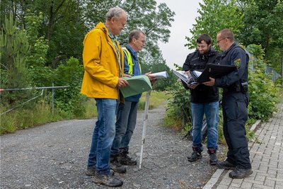 Uwe Meier (Umweltamt), der Sachverständige Jörg Hofmann, Christopher Heilmann (Umweltamt) und Kriminalhauptmeister Dirk Wallner am Eingang des ehemaligen Schrottplatzes an der Robert-Blum-Straße.