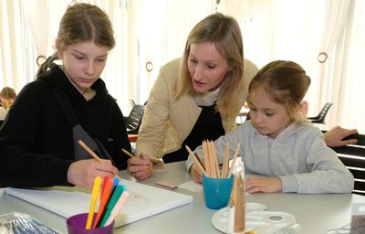 Olga Kotekhova (Mitte) mit Nika (11 Jahre) und Katya (6) aus Dnipro beim Malnachmittag für ukrainische Kinder im Haus Caroline. 