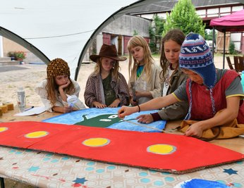 Luca (v. l.), Bruno, Hanna und Annika beobachten wie Michel ein Stück der Kulisse abmisst, die die Kinder für den Auftritt selbst gestaltet haben.