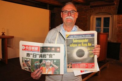 Bernd Hüttner zeigt Zeitungen, die über die Sonnenfinsternisse in ihren Ländern berichteten. 