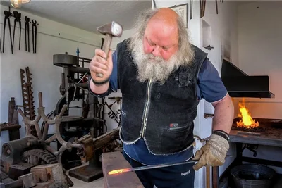 Kunstschmiedemeister Jan-Peter Nitzsche formt das glühende Metall auf dem Amboss. 